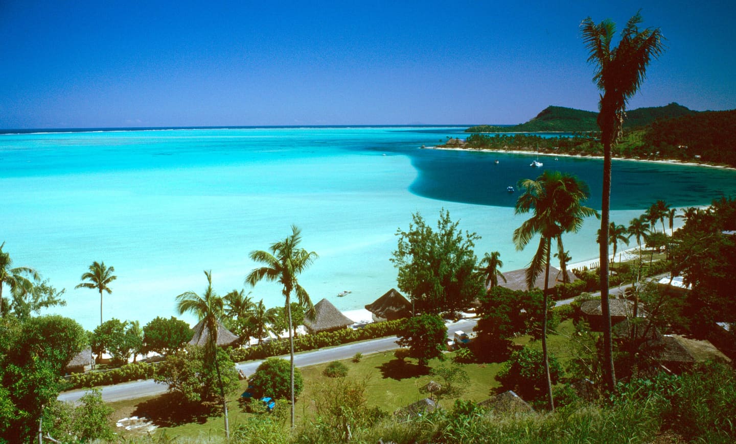 Matira Beach, Bora Bora — turquoise lagoon edged by coconut palms, looking west across French Polynesia
